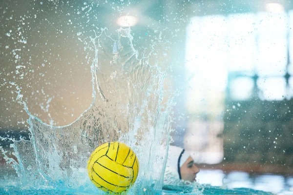 Water polo, ball and splash with athlete in swimming pool training, exercise and fitness game or sports event. Professional swimmer, person or woman in competition, challenge stroke and object action.