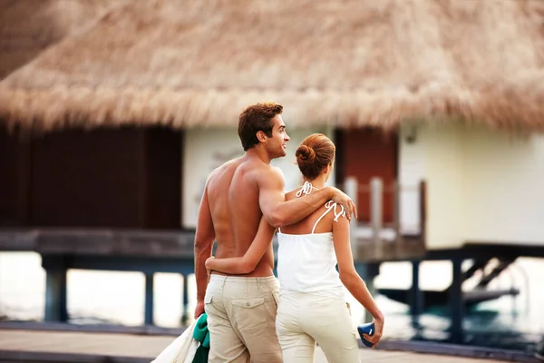 A stroll in paradise - VacationsRomance. Rear-view of a loving couple returning to their bungalow after a romantic stroll
