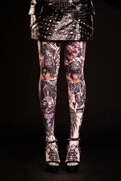 Head to toe tattoo style. Studio shot of a womans tattooed legs