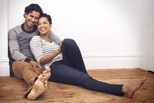 Home sweet home with my love. Full length shot of an affectionate couple sitting on the floor at home