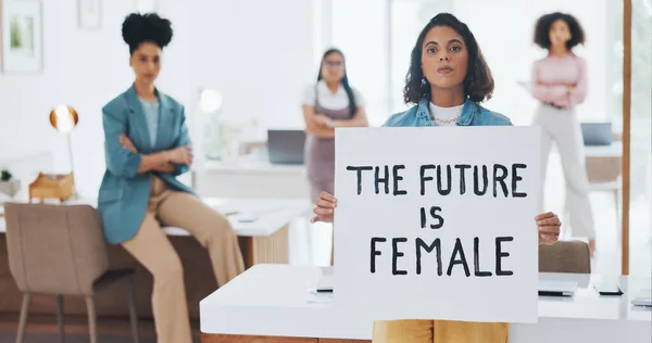 Equality, empowerment and female leader holding a sign in the office with her business woman group at work. Future, human rights and diversity with a feminism team working for revolution or change.