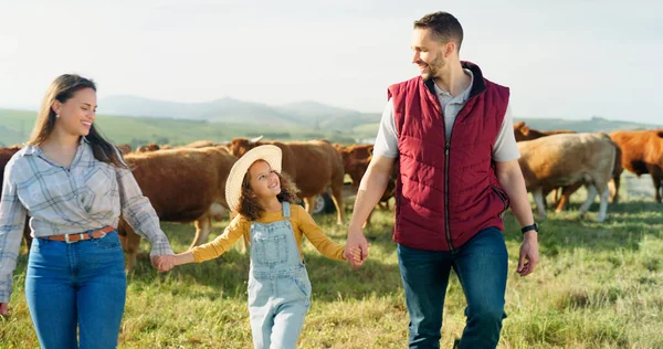 Farmer family, cow farm and field walk with girl and parents bonding in nature, enjoying conversation and relaxing. Agriculture, sustainable business and happy family having fun in the countryside.