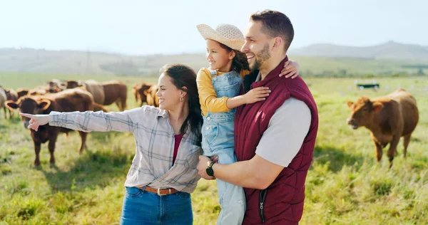 Farm, cattle and family on holiday in the countryside of Argentina for a sustainable lifestyle in summer. Mother, father and kid on the grass of a field for animal cows during a vacation in nature.