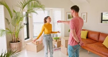 Moving, couple and man with keys for woman, hug and real estate success, happy and smile in their new house. Property, purchase and young homeowner sharing good news with girlfriend about home loan.