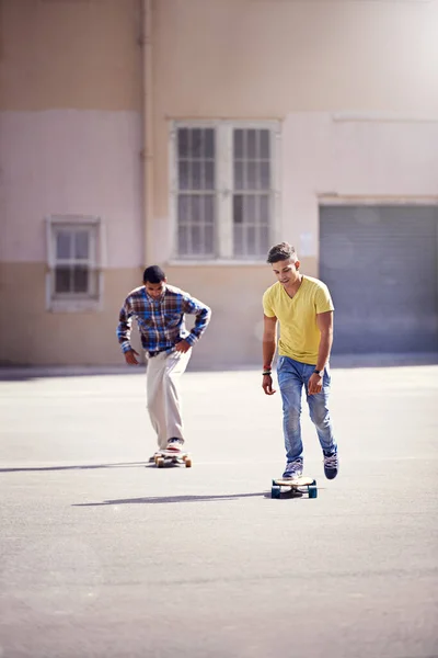 Skateboarding is a part of their lifestyle. two young men skateboarding at a skate park