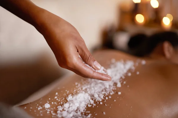 Soothing salts to ease my soul. a young woman enjoying a salt exfoliation treatment at a spa