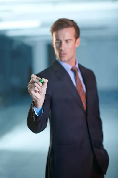 stock image Making his mark. a handsome young businessman writing on a transparent surface with a marker