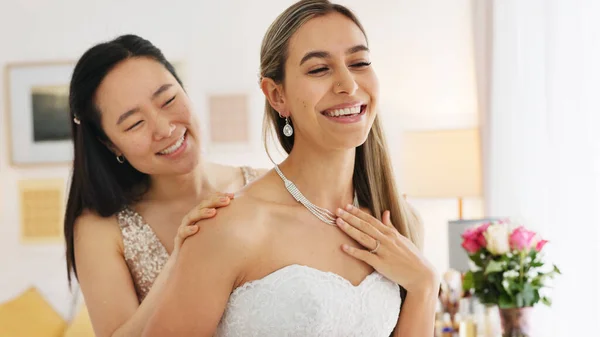 Wedding, friends and bride with necklace jewelry for beauty, wealth and luxury with happiness and fashion lifestyle. Happy women and bridesmaid in dressing room helping with silver diamond chain.