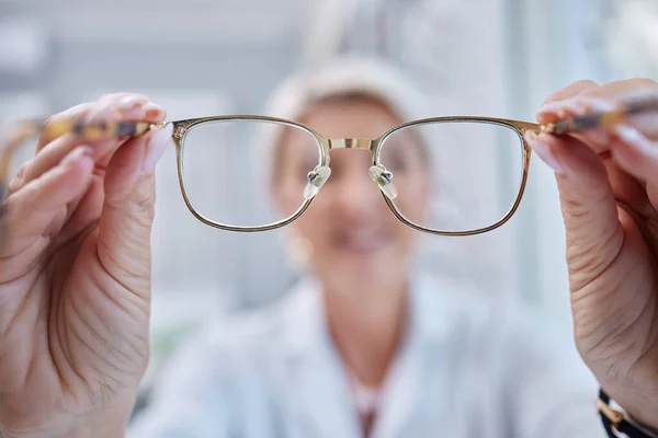 Glasses, vision and optometrist doctor hands for eye wellness and health test in a shop or hospital. Healthcare, consulting and medical employee holding a frame with tested lens for customer.