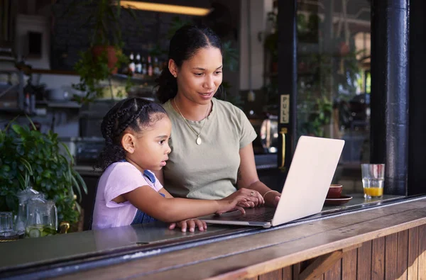 Black family, internet cafe or laptop with a mother and daughter together in the window of a restaurant. Kids, computer or education with a woman and female child sitting or bonding in a cafe.