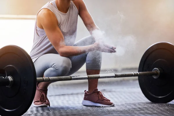 Hands, weightlifting and powder with a woman bodybuilder getting ready to exercise or workout at gym. Fitness, grip and training with a female weight lifter bodybuilding for strong muscles or health.
