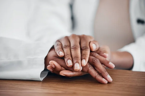 Doctor, patient and holding hands for help, trust and support for medical problem, depression or cancer. hand of a healthcare person and patient talking about sad results, mental health and empathy.