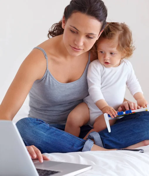 Showing her the ways of technology. A young mother juggling her work and personal life