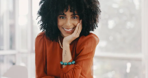 Face, vision and mindset with a business black woman sitting at a desk with her hand on her chin. Portrait, happy and smile with a female employee thinking about future growth or company development.