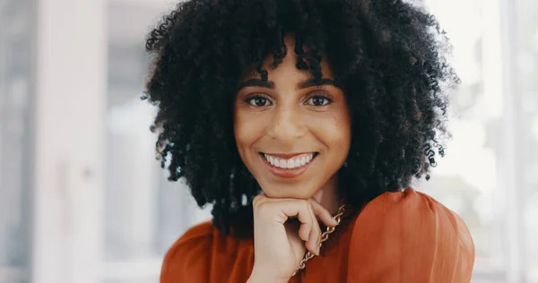 Face, vision and mindset with a business black woman sitting at a desk with her hand on her chin. Portrait, happy and smile with a female employee thinking about future growth or company development.