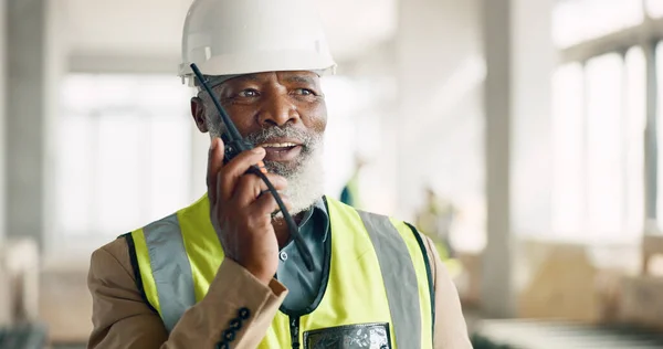 Senior engineer, walkie talkie and black man at construction site talking, speaking or working. Communication, radio tech and elderly architect from Nigeria in discussion or chat on building project.