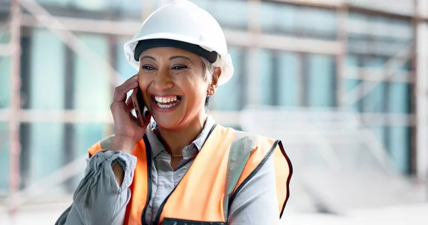 Construction site, contractor and happy woman developer phone call planning for logistics, industrial engineering and city project management. Laughing mature architect manager talking on smartphone.