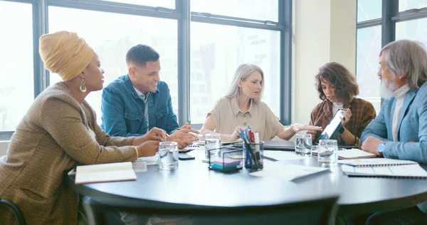 stock image Business people, tablet and teamwork for planning, strategy and ideas by desk in modern office for goal. Corporate group, digital tech and finance team for brainstorming, vision or target in New York.