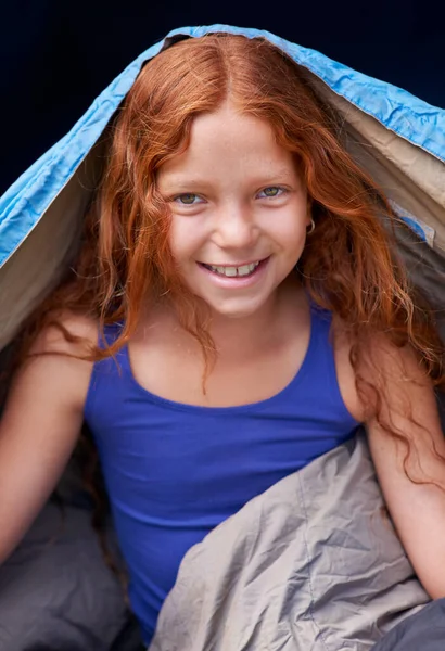 I love my sleeping bag. Portrait of a young girl sitting in her sleeping bag
