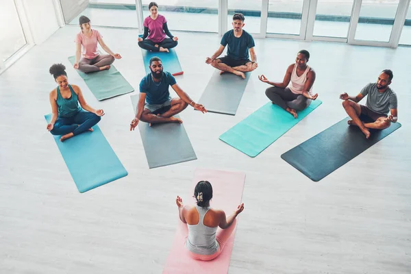Yoga class, exercise and meditation with people for fitness, health and wellness above. Diversity men and women in health studio for lotus workout, mental health and body balance with zen coach.
