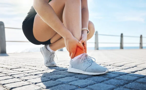 Fitness, hands or runner with ankle pain at a beach after exercising, body training injury or outdoor workout. Red glow, or injured sports athlete suffering from broken foot after running exercise.