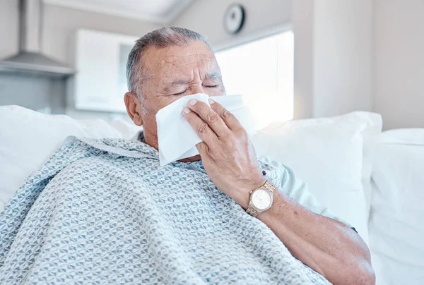 Sick, allergy and senior man on sofa cleaning his nose with retirement, pension or elderly healthcare at home. Virus, bacteria or allergies risk, sad and tired old person on couch in house self care.