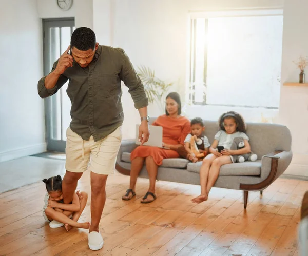 A mixed race family of five in the living room together. One African American father talking on a cellphone and running late while his daughter is desperate for him to stay.