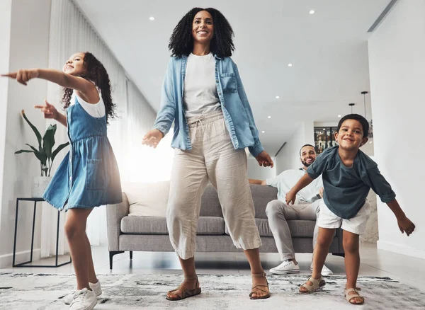 Happy family, fun and dance in a living room by mother and children playing, bonding and happy in their home. Kids, parents and dancing game in a lounge on a weekend, cheerful and happiness together.