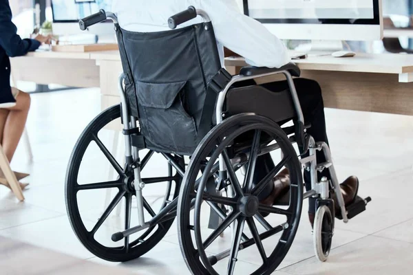 Wheelchair, office and business man disability in the workplace doing administrative assistant work. Working, computer and desk job of a worker back with technology in a coworking space with staff.