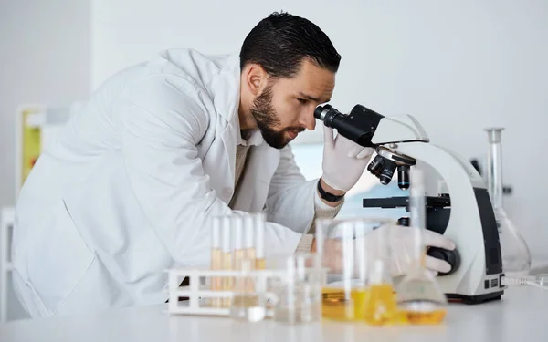 Science, microscope and medical with a doctor man at work in a laboratory for innovation or development. Research, analytics and biotechnology with a male scientist working in a lab for breakthrough.