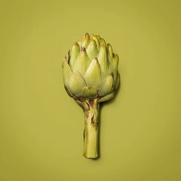 Some butter and salt is all you need. an artichoke against a studio background