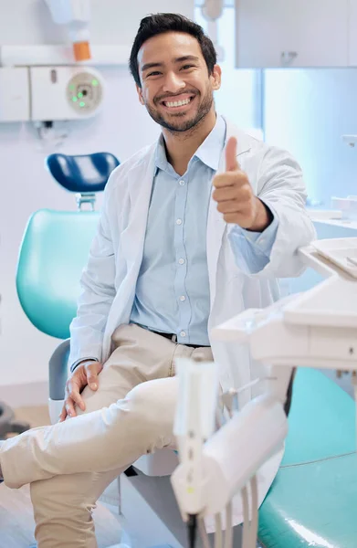 Im here to do my best. a young male dentists giving the thumbs up in his office