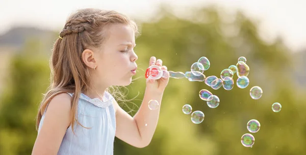 Pretty bubbles floating in the air. a little girl blowing bubbles in a park
