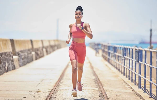 Black woman, running and fitness with runner outdoor, athlete with cardio and speed with run on bridge. Runner, active and sports with workout, exercise and training for marathon or race with mockup.