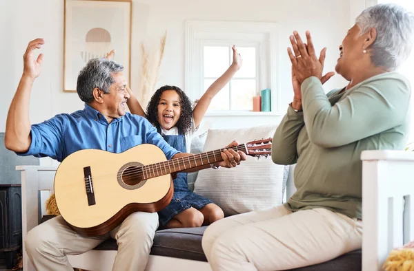 That deserves an applause. a grandfather playing guitar for his grandchild at home