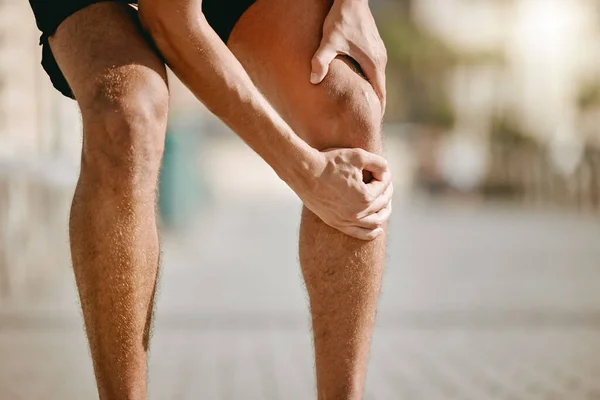ランナーやフィットネスヘルスケアのリスク 筋肉の事故や都市でのトレーニングの問題のための男の手の膝の痛み マッサージのためにストリートで停止運動選手のランニング 心臓やワークアウトの足の怪我 — ストック写真