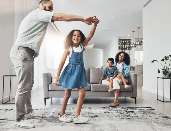 Happy family, dance and music in a living room by girl and father playing, bonding and happy in their home. Kids, parents and dancing game in a lounge on a weekend, cheerful and happiness together.