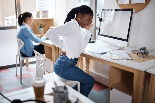 Sitting for hours is no good. a young businesswoman experiencing back pain while working at her desk in a modern office