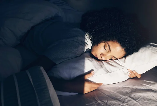 Black woman, bed and sleeping at night for peace, quiet and rest or relax in home bedroom. Person with pillow to dream, security or for calm sleep with nap or comfort with duvet for wellness.