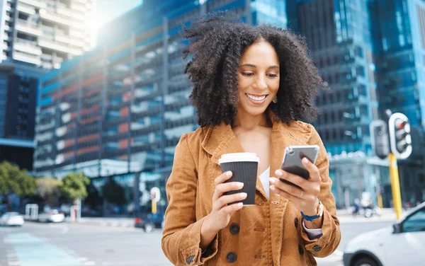 Black woman, urban city and coffee with phone on social network, internet search and smile. Happy female walking in street with mobile technology, smartphone and reading notification on 5g connection.
