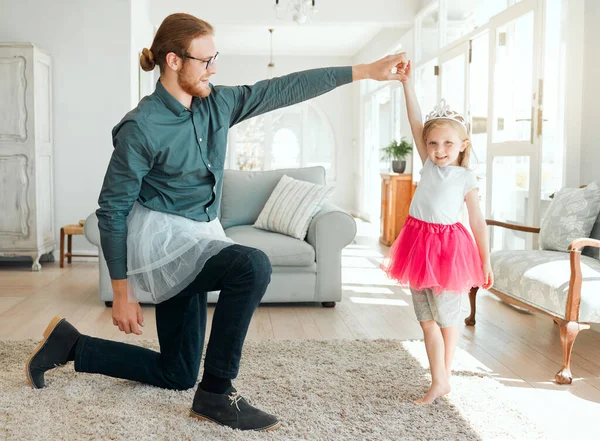 Lets see your routine sweetie. Full length shot of an adorable little girl wearing a tutu and dancing with her father in the living room