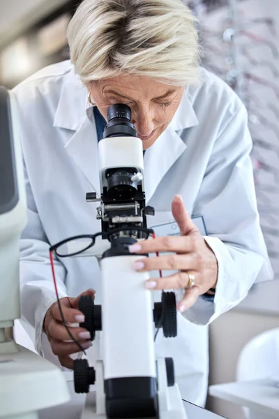 ophthalmology, microscope and glasses with a woman doctor with tools to check lens for eye care. Medical person at work for science, vision and health insurance while working in lab, store or clinic.
