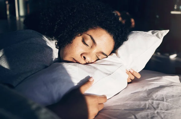 Black woman, sleeping and pillow in morning for peace, quiet and rest or relax in home bedroom. Person on bed to dream or for calm sleep with sleepy or stress relief for health and wellness.