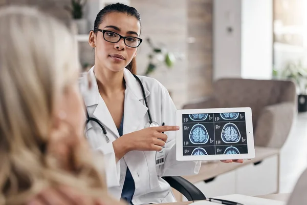 Brain, woman and doctor pointing at tablet, mri scan or xray diagnosis for cancer. Healthcare, advice and neurology patient in doctors office, help consulting on health problem for hospital treatment.