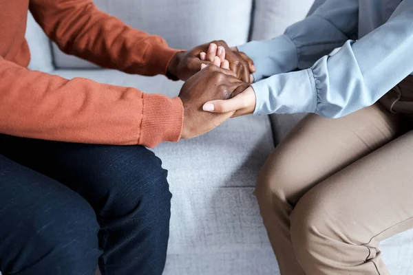 stock image Holding hands, black couple and therapy help on sofa for support, solidarity and listening for love in relationship. Man, woman and couch for helping hand at psychology, consultation or trust problem.