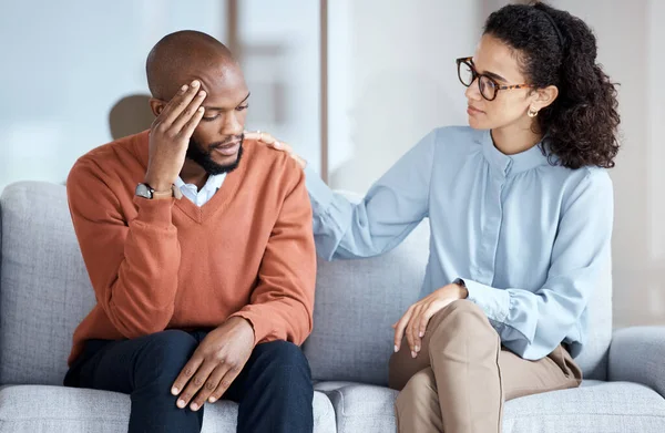 Therapy, counselling and mental health support for black man patient on psychologist couch. Person talking to woman therapist about psychology, anxiety and depression or stress for help or support.