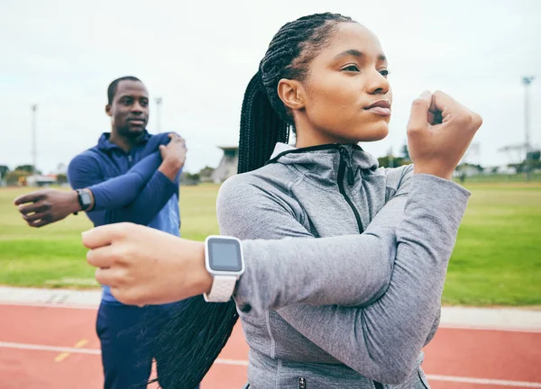 Fitness, black couple and stretching arms for exercise, health and wellness at stadium. Winter sports, training or man and woman prepare and get ready to start workout, running or exercising outdoors.