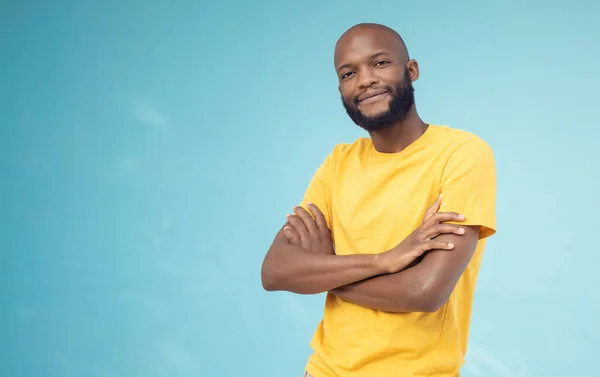 Black man, portrait smile and arms crossed on mockup for advertising or marketing casual fashion. Happy African American male standing in confidence smiling for profile on a blue studio background.
