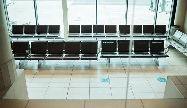 Empty airport, seats or furniture in departure lounge, covid compliance or coronavirus lockdown in global healthcare laws. Air travel, chair or waiting area and nobody in bacteria control management.