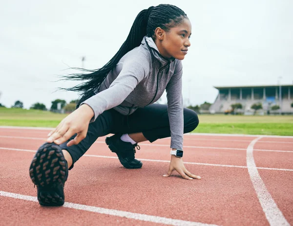 Fitness, exercise and black woman stretching legs for health and wellness at stadium outdoors. Winter sports, training runner and female prepare and get ready to start workout, running or exercising